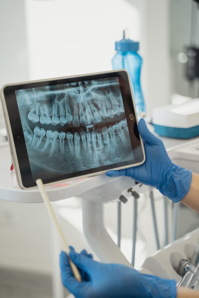 pexels-photo-5355695 Dentist displaying dental x-ray on tablet in a modern clinic.